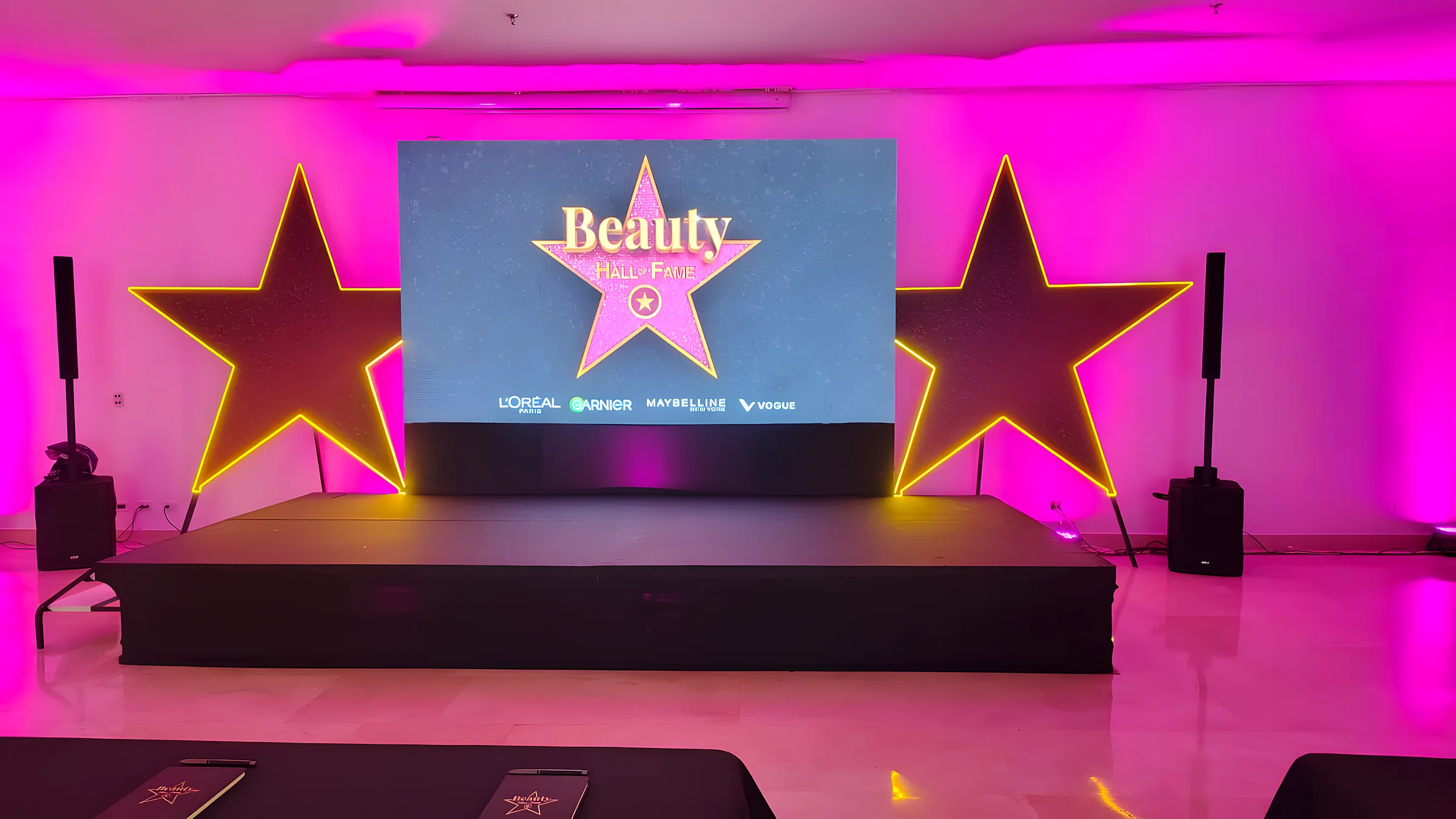Escenario con pantalla LED y estrellas iluminadas en magenta